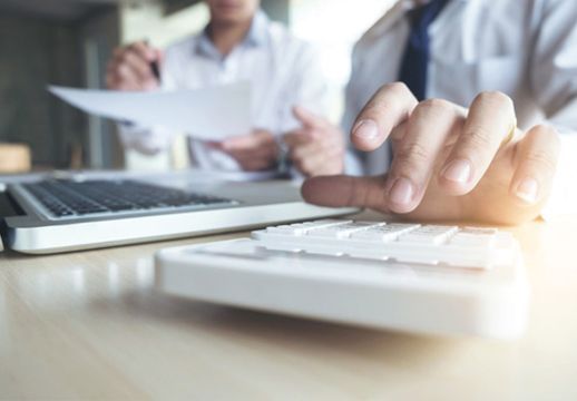 Immobilienmakler kalkuliert eine Immobilien-Finanzierung.